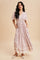 woman wearing a floral print maxi dress with short sleeves and pockets, standing against a neutral background