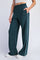 woman wearing dark teal wide-leg sweatpants with white side stripes and pockets