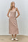 woman wearing a tan ribbed maxi dress with buttons and side pockets, styled with white sneakers