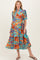 woman wearing a colorful floral print maternity dress with a tiered skirt and short sleeves, displaying a baby bump