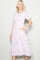 woman wearing a pink floral midi dress with puff sleeves and pockets
