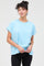 woman wearing a light blue oversized t-shirt with short sleeves and a relaxed fit, paired with black pants