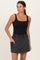 woman wearing a black tank top and a gray drawstring waistband skirt with side pockets