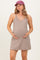 woman wearing a taupe maternity dress with pockets and holding her baby bump