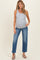 woman wearing a gray ribbed maternity tank top and blue straight leg jeans, showing her baby bump