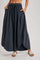 woman wearing a black maxi skirt with an elastic waistband and pockets, styled with light sandals