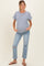 woman wearing a navy and white striped maternity t-shirt and distressed light blue jeans with a visible baby bump