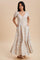 woman wearing a cream floral maxi dress with puff sleeves and pockets, standing on a beige background