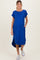 woman wearing a bright blue maternity maxi dress with short sleeves and pockets, showing her baby bump