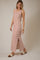 woman wearing a white and red striped sleeveless maxi dress with a side slit and stylish sandals