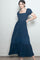 woman wearing a navy blue tiered maxi dress with puff sleeves and square neckline
