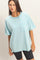 woman wearing an oversized light blue t-shirt with a front pocket and black bike shorts