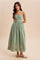 woman wearing a light green maxi dress with embroidered palm tree details and adjustable spaghetti straps