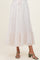 woman wearing a light pink maternity skirt with floral print and ruffle hem