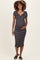 woman wearing a black and white striped maternity dress with a fitted silhouette and a scoop neckline, holding her baby bump