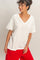 woman wearing a white oversized v-neck t-shirt with short sleeves and paired with red loose-fitting pants