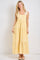 woman wearing a yellow gingham maxi sundress with ruffled straps and a tiered hem