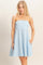 woman wearing a light blue striped strapless sundress with pockets