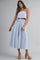 woman wearing a striped blue two-piece set featuring a cropped top and a high-waisted skirt