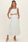 woman wearing a light green and white striped maternity crop top and matching maxi skirt with pockets