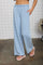 woman wearing light blue wide-leg lounge pants with an elastic waistband and side pockets
