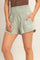 woman wearing light green smocked waist shorts with side pockets