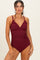 woman wearing a burgundy ribbed one-piece swimsuit with adjustable straps and wooden accent details