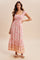 woman wearing a pink floral maxi dress with smocked bodice and ruffled sleeves