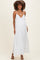 woman wearing a white maternity maxi dress with a deep v-neck and adjustable straps, showcasing her baby bump