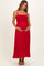 woman wearing a red maternity maxi dress with a smocked bodice, holding her baby bump