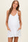 woman wearing a white maternity dress with pockets and a visible baby bump