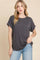 woman wearing a dark gray short sleeve loose-fit t-shirt with rolled sleeves and light blue jeans