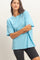 woman wearing a light blue oversized t-shirt with short sleeves and black bike shorts