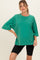 woman wearing a green oversized maternity tee paired with black bike shorts