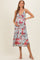 woman wearing a light blue floral maternity dress with a v-neckline and baby bump visible