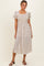 woman wearing a cream polka dot midi dress with puff sleeves and a square neckline