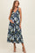 woman wearing a black floral maternity dress with a v-neck and tiered skirt, holding her baby bump