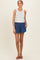 woman wearing a striped maternity tank top with denim shorts, showing a relaxed style for summer wear