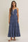 woman wearing a denim tiered maxi dress with spaghetti straps and a tie detail at the neckline