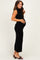 woman wearing a black ribbed maternity dress, highlighting her baby bump, styled with open-toe block heels