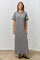 woman wearing a long striped grey maxi dress with scalloped edges and short sleeves