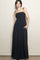 woman wearing a black smocked maxi dress with adjustable straps and side pockets
