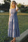 woman wearing a sleeveless blue polka dot maxi dress with a smocked bodice and tiered skirt
