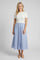 woman wearing a white short sleeve top with a blue and white striped midi skirt and beige heels