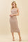 woman wearing a beige and brown striped sleeveless midi dress with side slits and a fitted silhouette