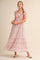 woman wearing a pink floral maxi sundress with ruffled details and tie straps