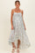 woman wearing a light blue floral maternity maxi dress with spaghetti straps and a flowy hem, showcasing her baby bump