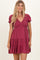 woman wearing a burgundy short puff sleeve dress with a v-neck and tiered skirt