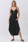 woman wearing a black sleeveless midi dress with a keyhole detail and pockets, standing against a light background