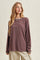 woman wearing a maroon and cream striped long sleeve top with a relaxed fit and round neckline